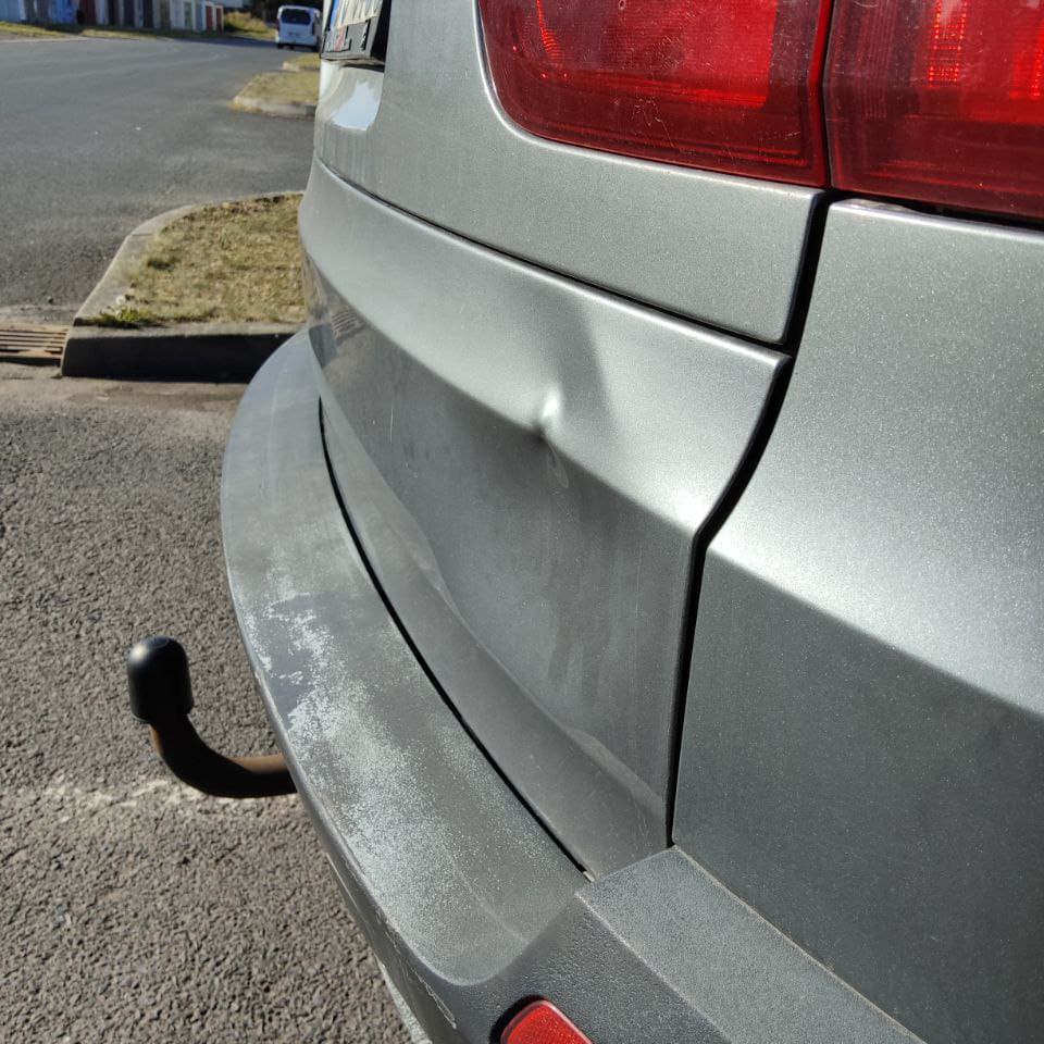 Оформление страхового случая: мастер ŽÁDNÉ DŮLKY осматривает повреждения кузова под PDR-лампой