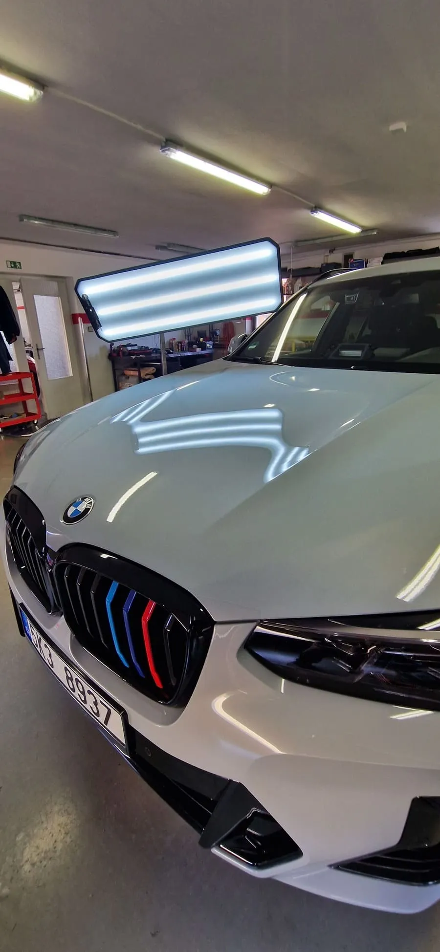 Капот белого BMW после ремонта вмятины методом PDR без покраски