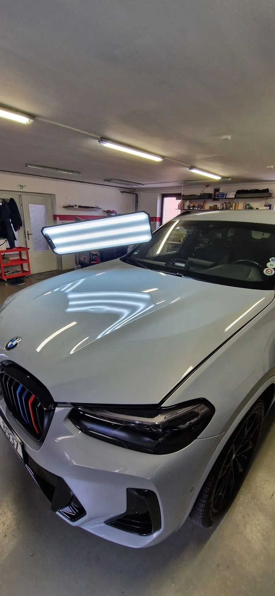Вмятина на капоте белого BMW перед возвратом автомобиля из лизинга