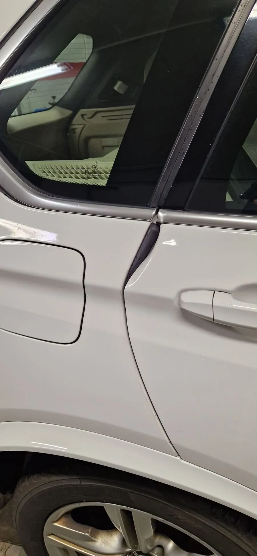 Poškození boční části bílého auta po vandalismu před posouzením opravy